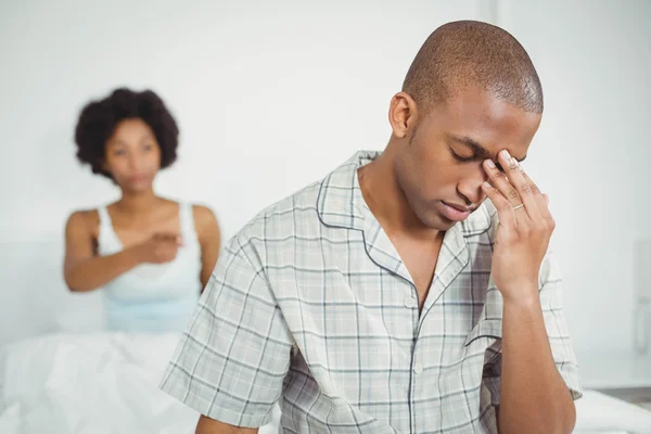 Upset man sitting on bed after argument — ストック写真