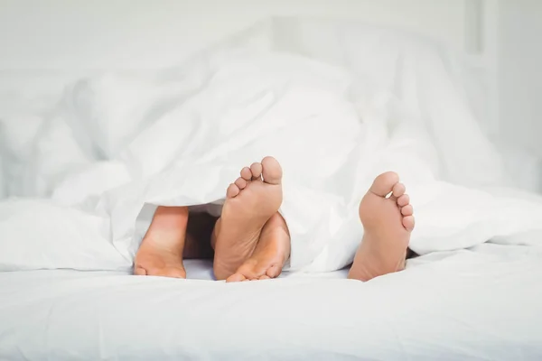 Feet sticking out from the blanket — Stock Photo, Image