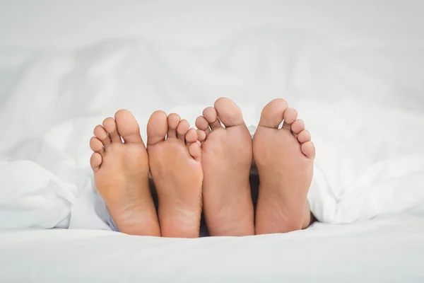 Feet sticking out from the blanket — Stock Photo, Image