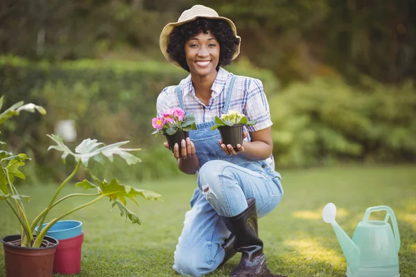 Mujer sonriente agachada en el jardín — Foto de Stock
