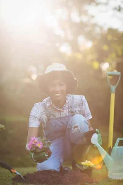 Smiling woman crouching in the garden — Stockfoto