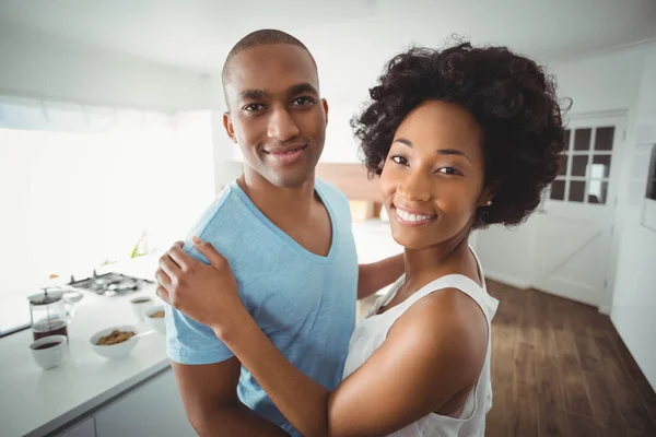 Sorrindo casal abraçando na cozinha — Fotografia de Stock