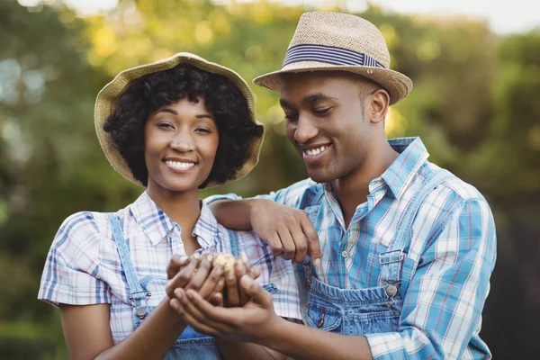 Smiling couple holding potatoes — Stock Photo, Image