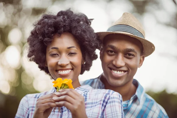 Smiling couple holding yellow flowers — Stock Photo, Image