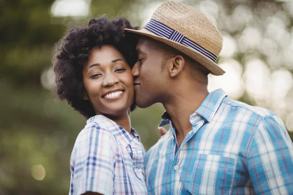 Smiling man kissing her girlfriends cheek — 图库照片