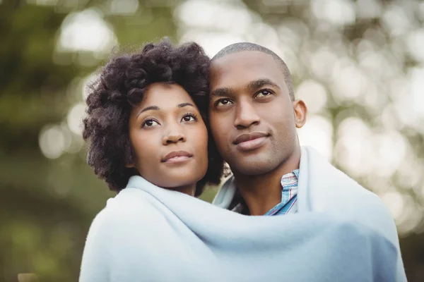 Couple under blanket looking up — Stockfoto