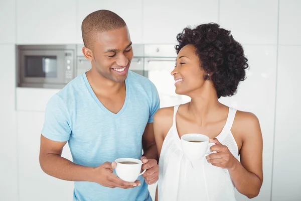 Smiling couple holding mugs — Stock Photo, Image