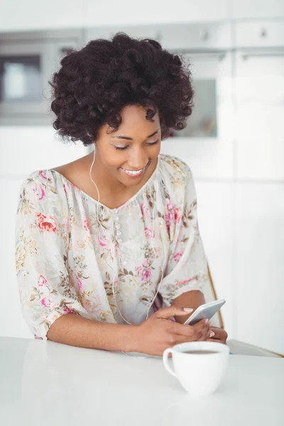 Woman with earphones using smartphone — Stok fotoğraf