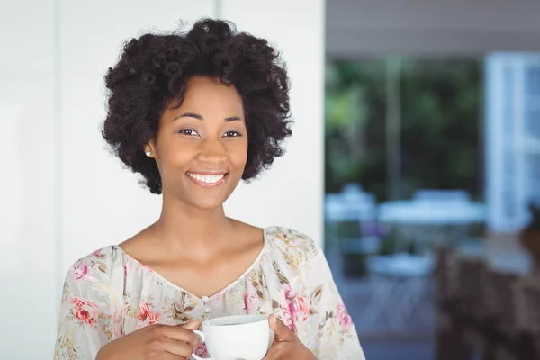 Mujer sonriente sosteniendo taza blanca — Foto de Stock