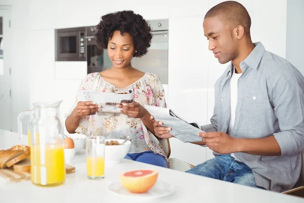 Couple reading magazine and documents — Stockfoto