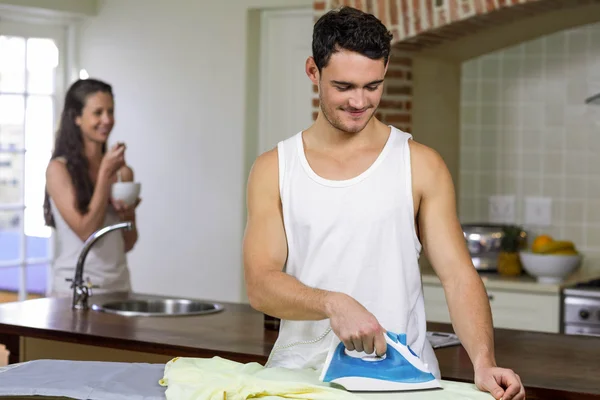 Hombre planchando una camisa en la cocina — Foto de Stock