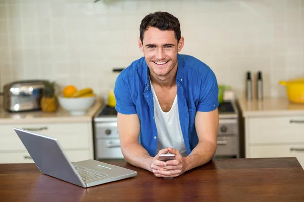 Young man leaning on kitchen worktop — Stock Fotó