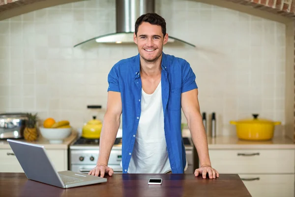 Giovane uomo appoggiato sul piano di lavoro della cucina — Foto Stock