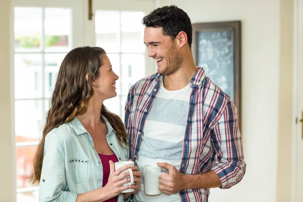 Happy couple standing with cup of tea — Stock Photo, Image