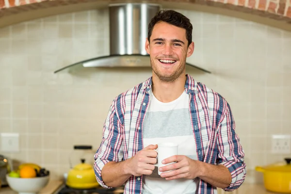 Young man holding a cup of coffee — Stock Photo, Image