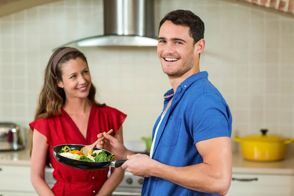 Par som håller kastrull med grönsaker och leende — Stockfoto