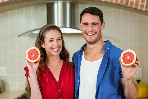 Pareja sosteniendo rebanadas de naranja sangre — Foto de Stock