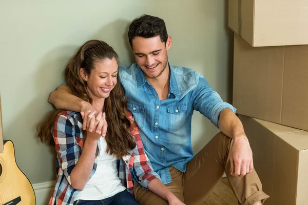 Pareja joven sentados juntos en el suelo y sonriendo — Foto de Stock