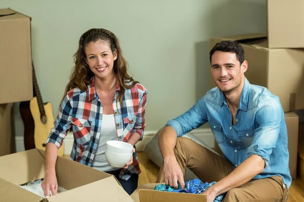 Pareja joven desempacando cajas de cartón —  Fotos de Stock