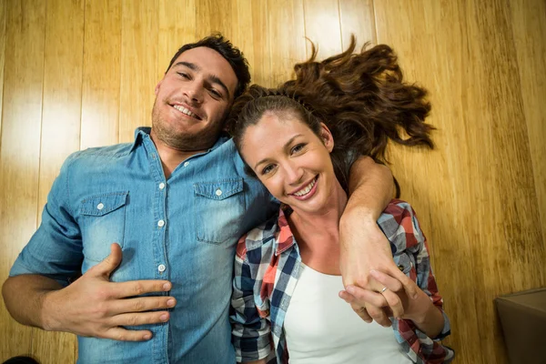 Jeune couple couché sur le sol dans leur maison — Photo