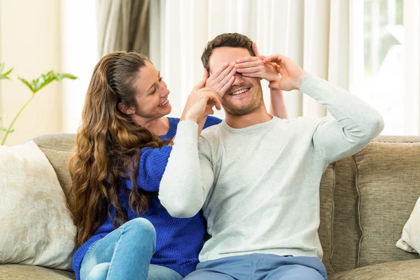 Woman covering mans eyes at home — Φωτογραφία Αρχείου