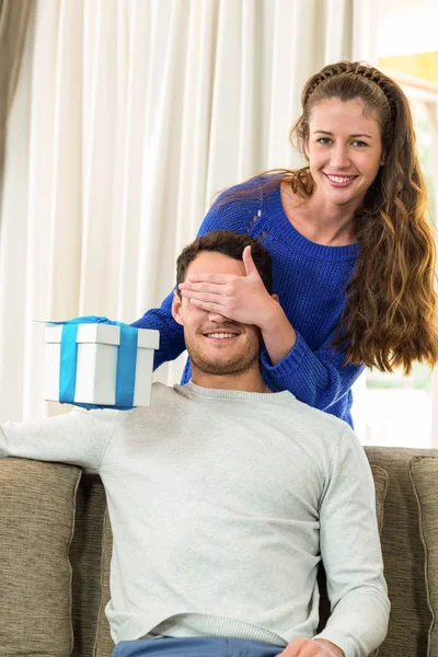Woman giving a surprise gift to her man — Φωτογραφία Αρχείου