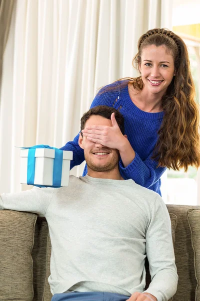 Mujer dando un regalo sorpresa a su hombre — Foto de Stock