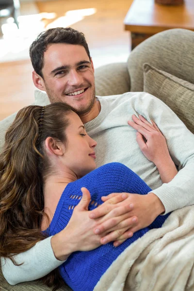 Jeune couple câlin sur canapé — Photo