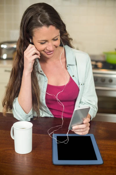 Молодая женщина слушает музыку на смартфоне — стоковое фото