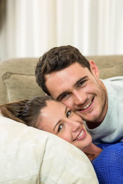 Retrato de jovem casal abraçando no sofá — Fotografia de Stock