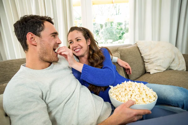 Ungt par äta popcorn på soffa — Stockfoto