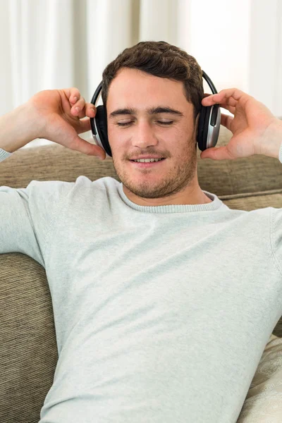 Joven sintiéndose relajado mientras escucha música — Foto de Stock