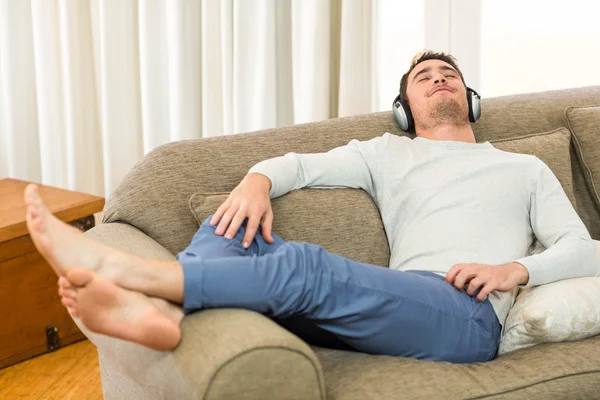 Junger Mann fühlt sich beim Musikhören entspannt — Stockfoto