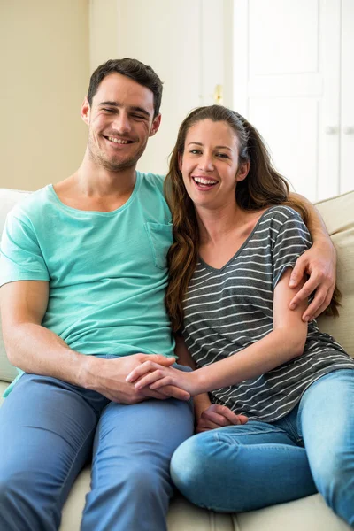 Jovem casal sentado no sofá — Fotografia de Stock