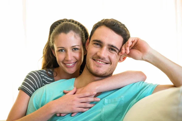 Porträt eines jungen Paares, das auf dem Sofa lächelt — Stockfoto