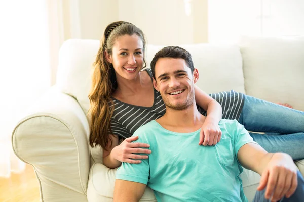 Retrato de jovem casal feliz desfrutando juntos na sala de estar — Fotografia de Stock