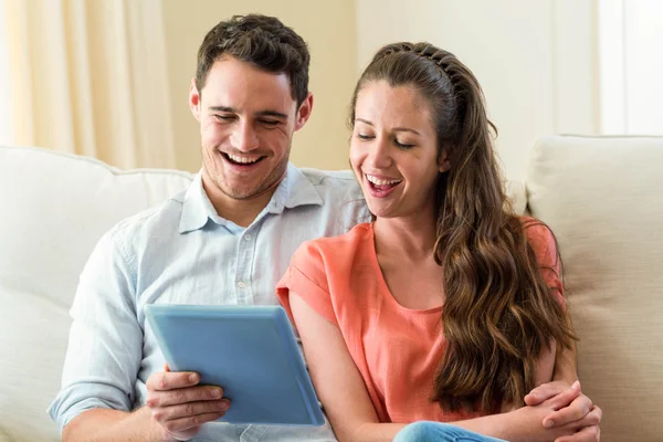 Casal jovem usando tablet digital no sofá — Fotografia de Stock