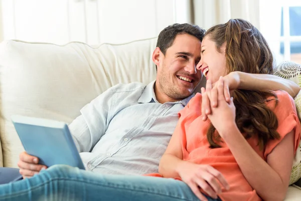 Young couple having fun on sofa — Stockfoto