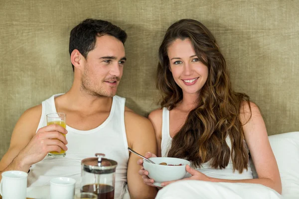 Giovane coppia che fa colazione sul letto — Foto Stock