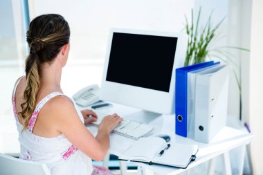 pregnant business woman typing on her computer clipart