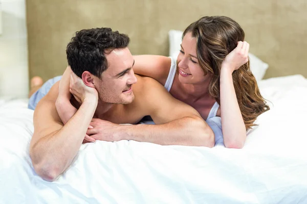 Sorridente coppia sdraiata a letto — Foto Stock