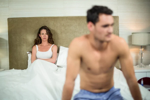 Расстроенная пара, сидящая на кровати — стоковое фото