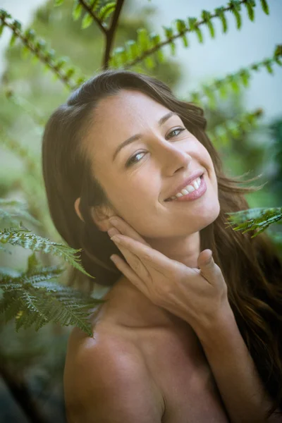Χαμογελαστή γυναίκα κοντά σε μερικά δέντρα — Φωτογραφία Αρχείου