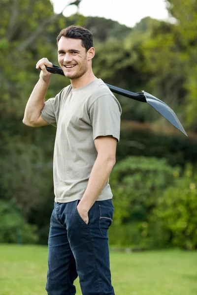 Young man standing with a gardening shovel — Stock Photo, Image