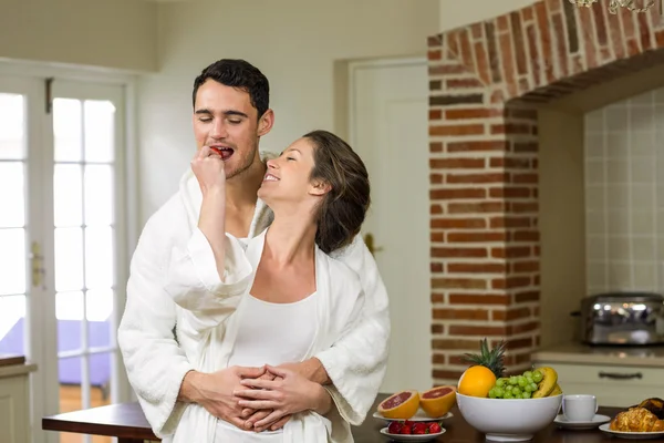 Hombre abrazando mientras mujer alimentación fresa a él —  Fotos de Stock