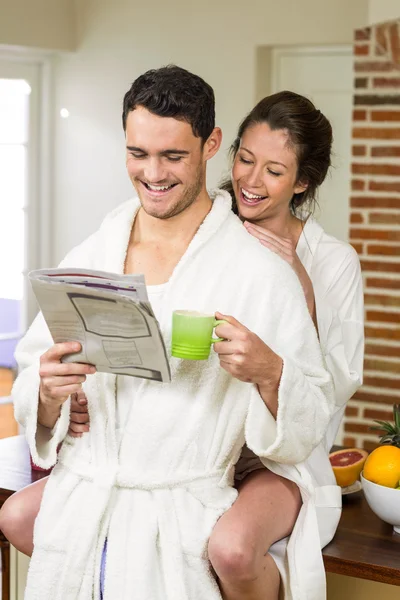 Pareja joven en albornoz tomando té — Foto de Stock