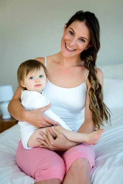 Sonriente mujer sosteniendo un lindo bebé — Foto de Stock