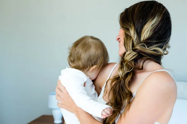 Uśmiechnięta brunetka dama trzyma dziecko — Zdjęcie stockowe