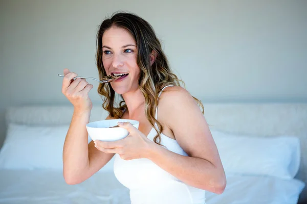 Lachende vrouw eten van een kom van granen — Stockfoto