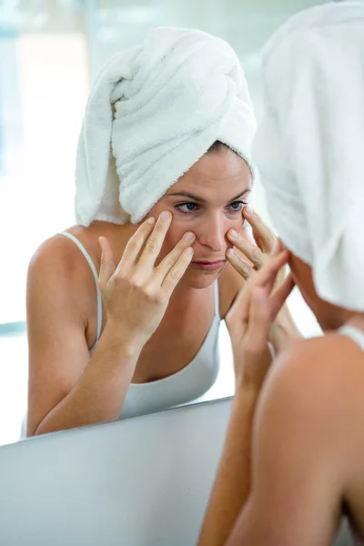 Vrouw in een haar handdoek inspectie van haar teint — Stockfoto